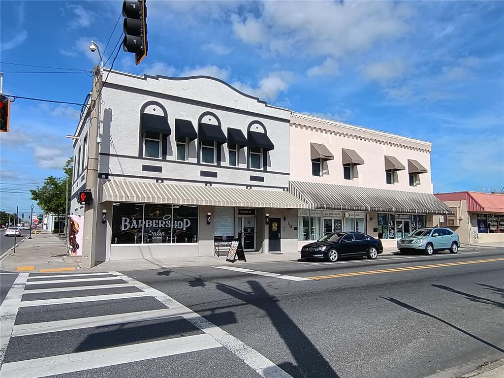 A two-story commercial building with a barbershop on the ground floor and striped awnings — 111 S COLLINS STREET, PLANT CITY, FL
