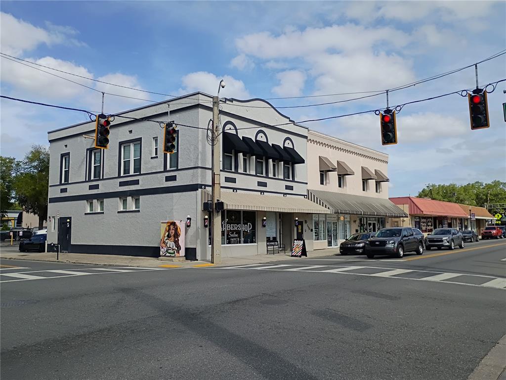 A street-level view of a two-story commercial building with a barbershop on a corner lot — 111 S COLLINS STREET, PLANT CITY, FL