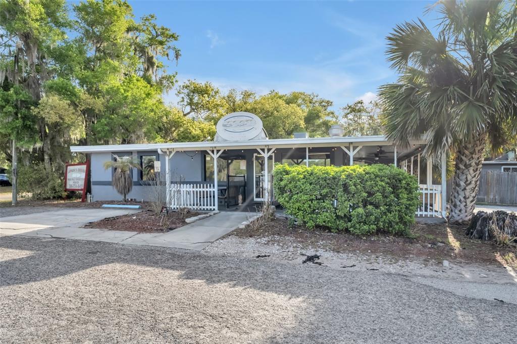 A single-story commercial building with a gray exterior, white trim, and a gravel parking area — 2200 N VOLUSIA AVENUE, ORANGE CITY, FL