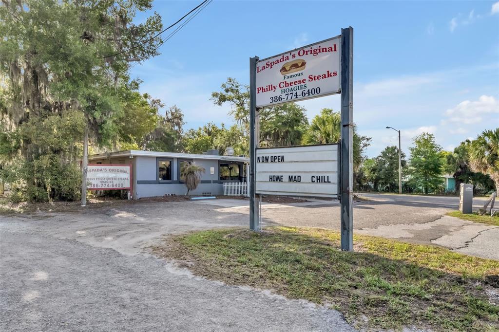 A restaurant building with a large roadside sign stands on a gravel lot — 2200 N VOLUSIA AVENUE, ORANGE CITY, FL