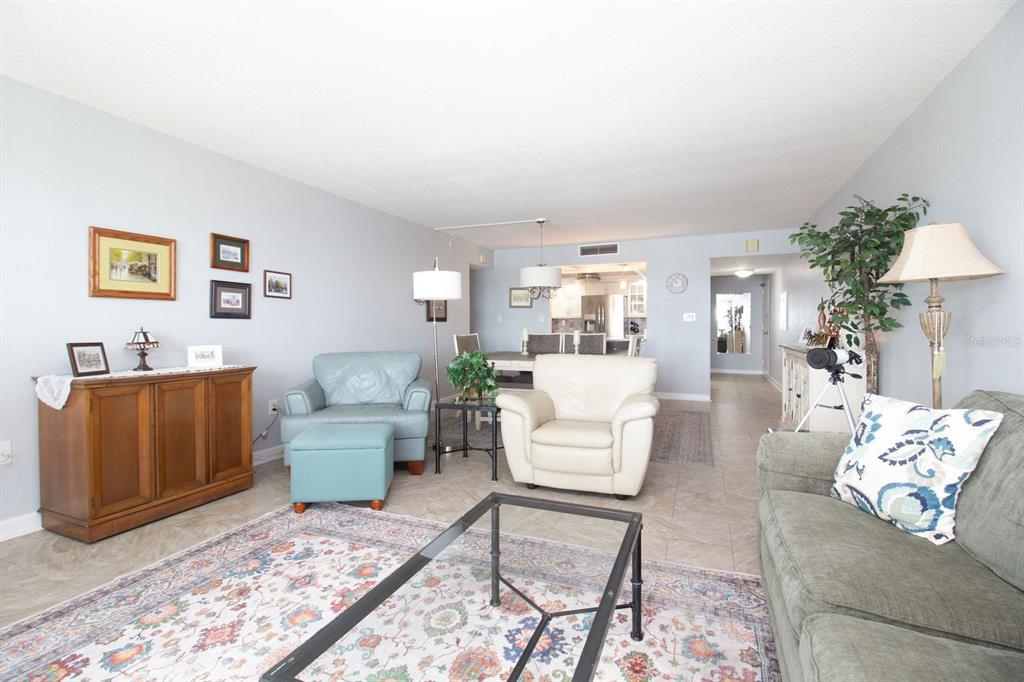 A living room with light blue walls, tile flooring, a patterned area rug, and furniture — 17920 GULF BOULEVARD UNIT 301, REDINGTON SHORES, FL