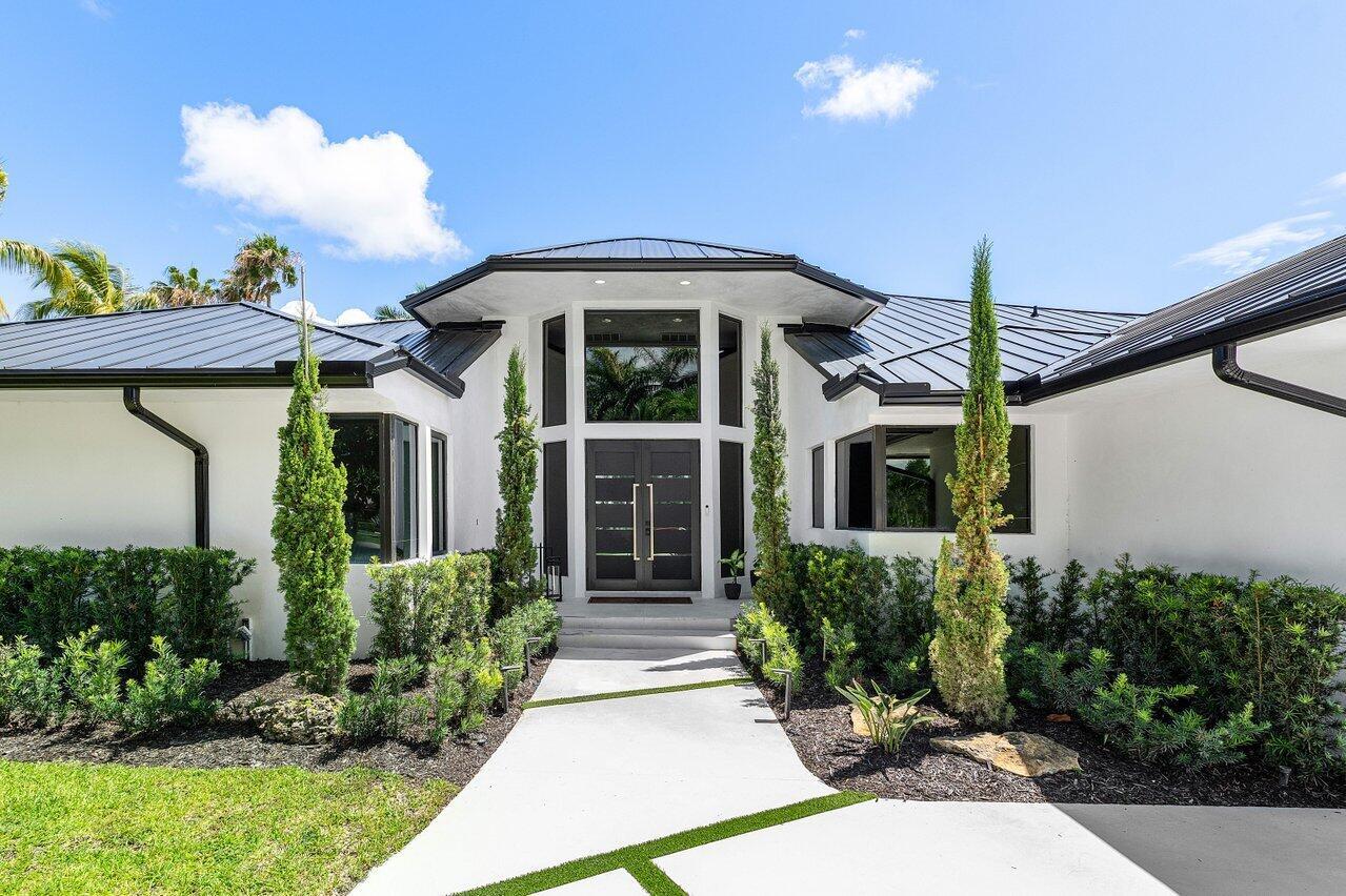 A modern white house with a dark metal roof and a central glass-paneled double door — 4825 Bocaire Boulevard, Boca Raton FL 33487, BOCA RATON, FL