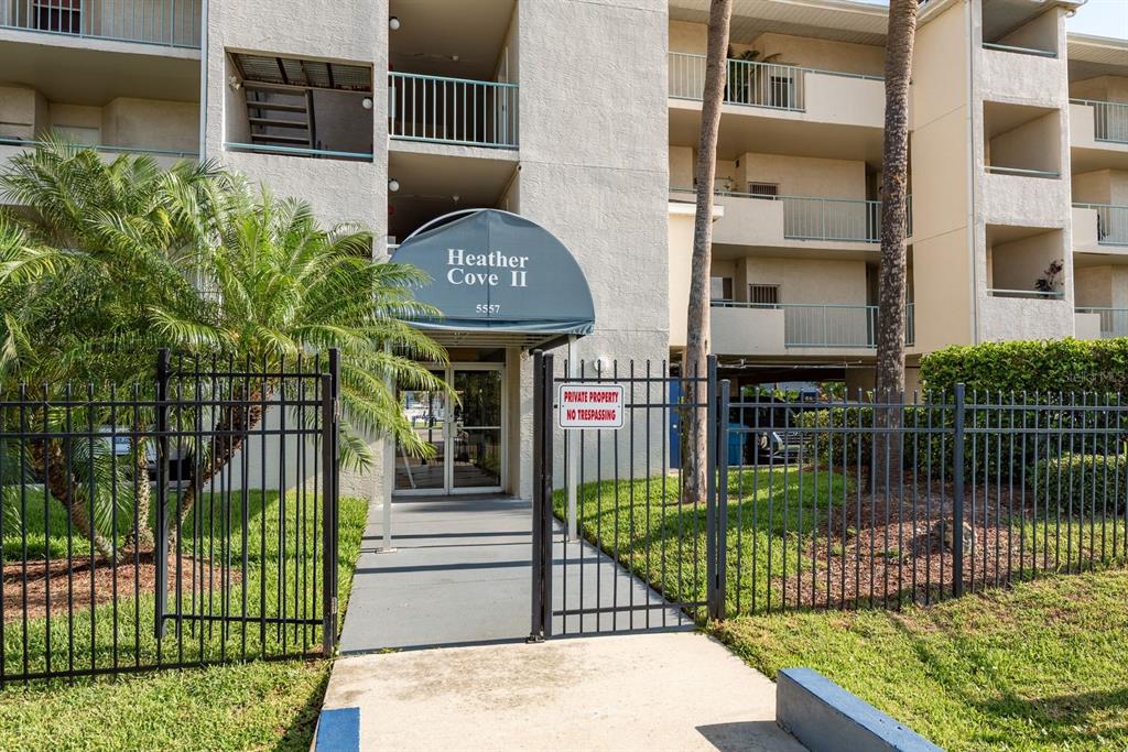 A kitchen with white cabinets, granite countertops, a double sink, and a tiled backsplash — 5557 SEA FOREST DRIVE UNIT 118, NEW PORT RICHEY, FL