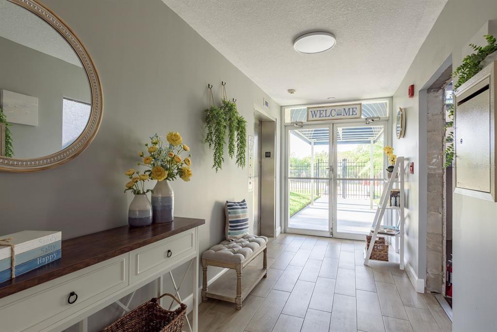 A kitchen with white cabinets, a glass-top stove, and a dining area with wood floors — 5557 SEA FOREST DRIVE UNIT 118, NEW PORT RICHEY, FL