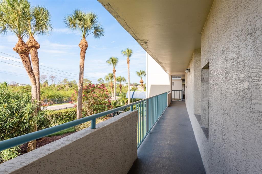 A kitchen with white cabinets, wood-look flooring, a rustic sideboard, and a floral wall art — 5557 SEA FOREST DRIVE UNIT 118, NEW PORT RICHEY, FL