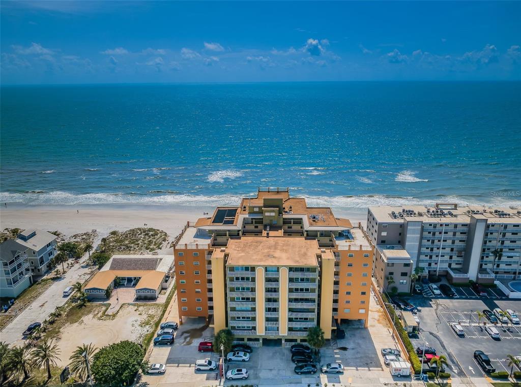 An aerial view of a multi-story beachfront condominium building with a parking lot — 18610 GULF BOULEVARD UNIT 610, INDIAN SHORES, FL