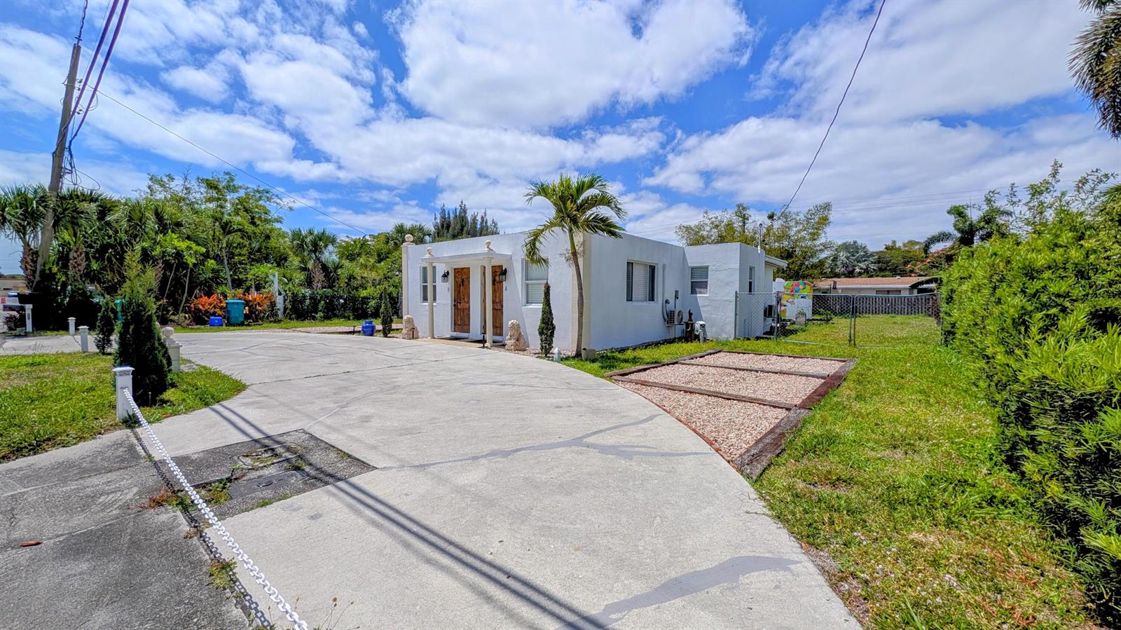 A white single-story house with a large concrete driveway and a gravel parking area — 407 NW 7th Street # A, Boynton Beach FL 33426, BOYNTON BEACH, FL