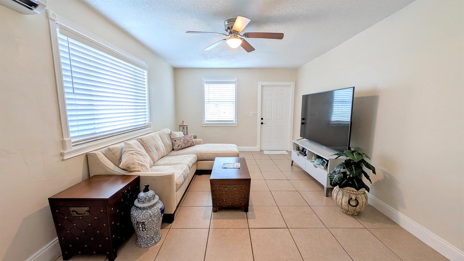 A living room features a beige sectional sofa, a wooden coffee table, and tile flooring — 407 NW 7th Street # A, Boynton Beach FL 33426, BOYNTON BEACH, FL