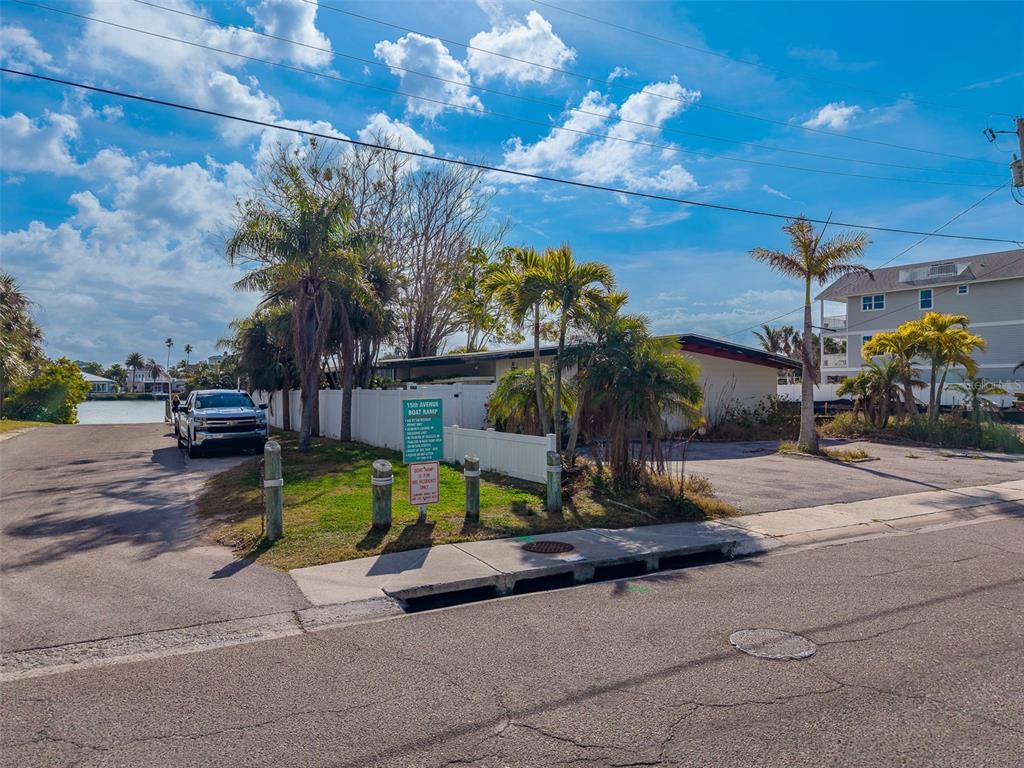 A paved driveway leads to a boat ramp beside a white fence and palm trees — 1217 BAY SHORE BOULEVARD, INDIAN ROCKS BEACH, FL