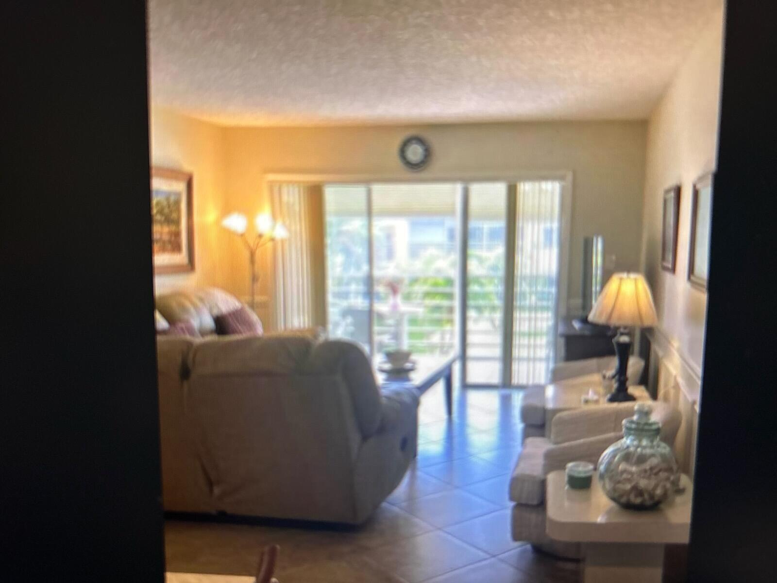 A living room features tile flooring, a large sofa, two armchairs, and sliding glass doors — 3212 Strawflower Way, FL 33467, FL