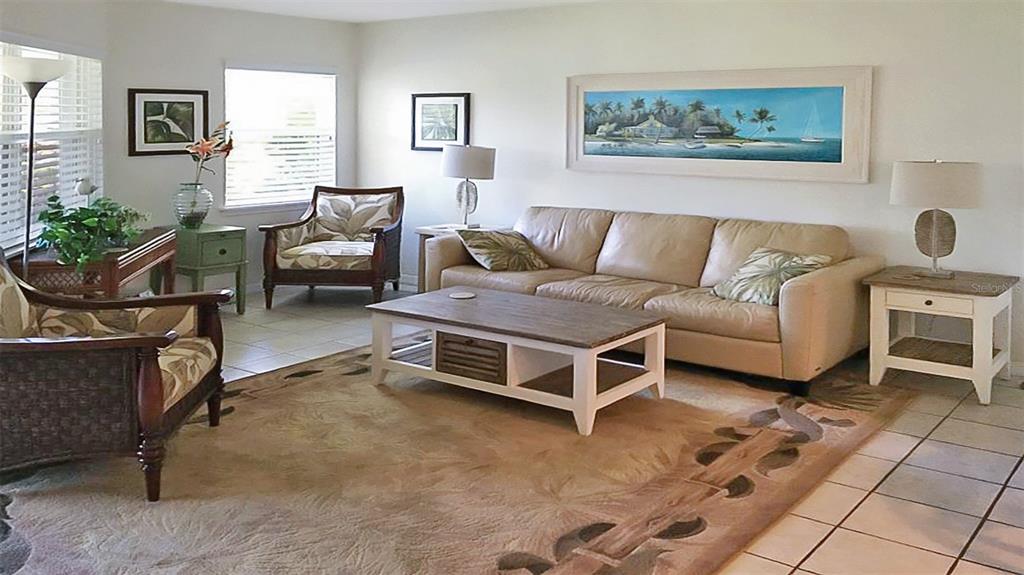 A living room features a beige sofa, two patterned armchairs, and a central wooden coffee table — 1327 SIESTA BAYSIDE DRIVE UNIT 1327-C, SARASOTA, FL