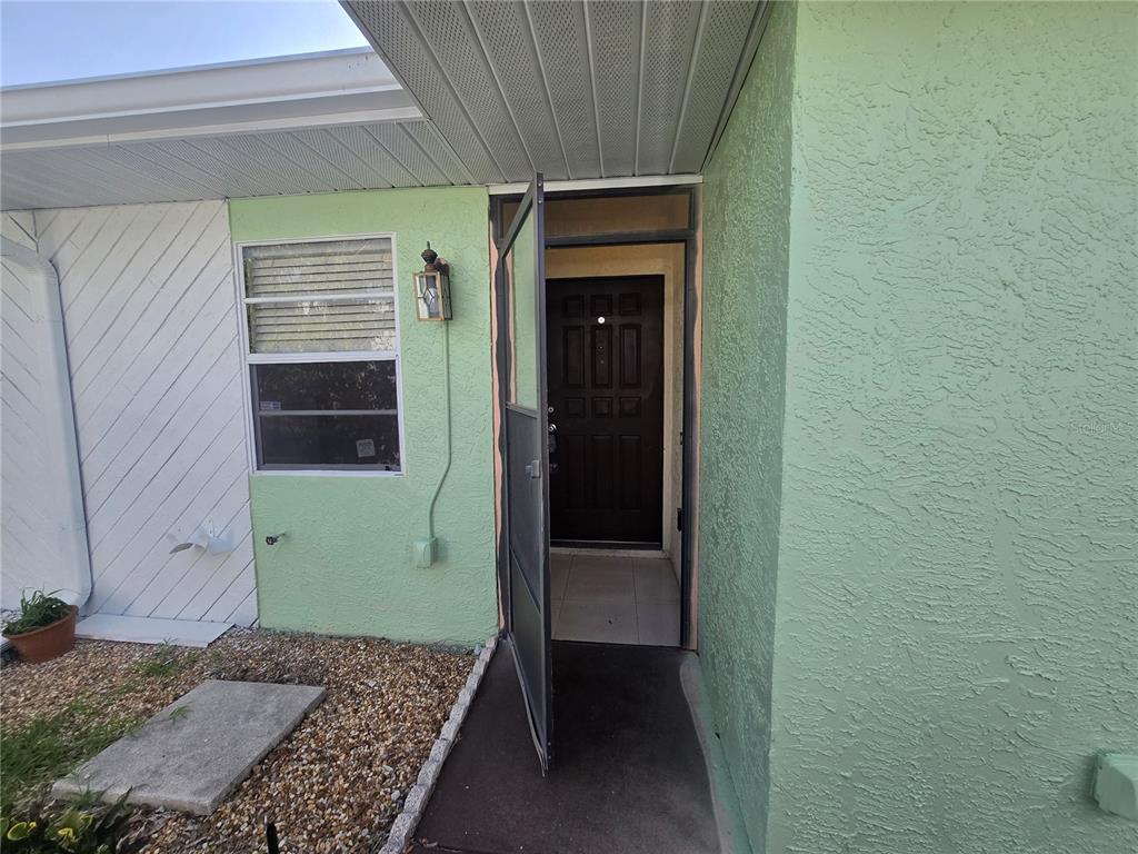 A small, enclosed storage space with white corrugated metal walls and a concrete floor — 6425 DREXEL DRIVE UNIT 2, PORT RICHEY, FL