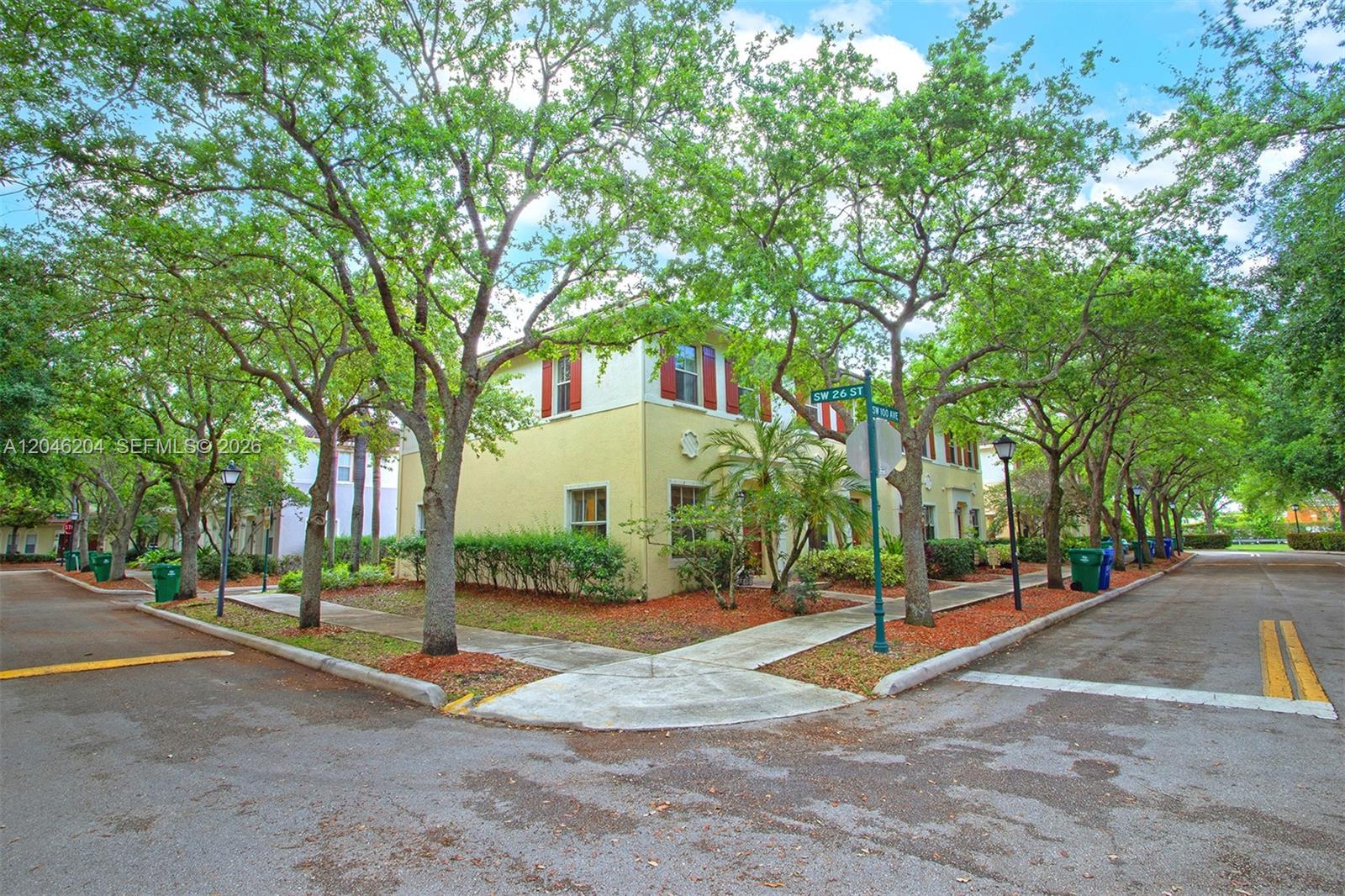 A two-story yellow stucco house sits on a corner lot shaded by mature trees — 2615 SW 100th Ave # 2615, Miramar FL 33025, MIRAMAR, FL