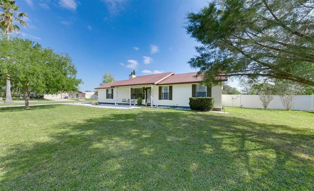 A single-story house with light siding and a brown roof sits on a grassy lawn — 1121 LONDONDERRY DRIVE, ORANGE PARK, FL