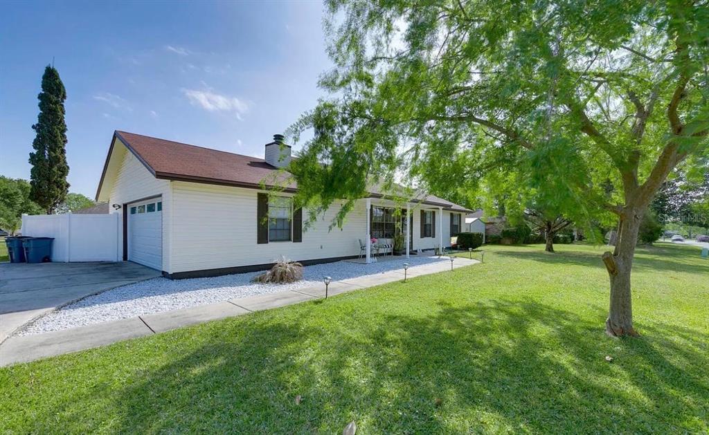 A single-story house with light siding, a brown roof, and a white garage door — 1121 LONDONDERRY DRIVE, ORANGE PARK, FL