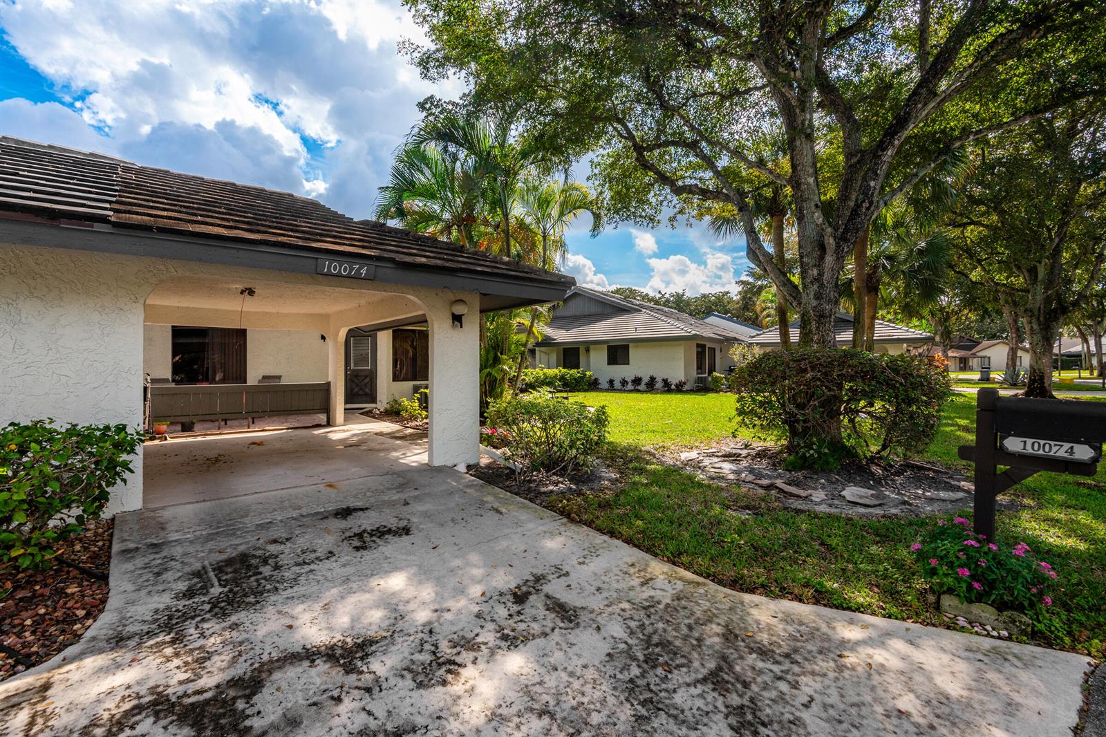 A single-story house with a covered carport, a concrete driveway, and a mailbox in front — 10074 Hickorywood Place, Boynton Beach FL 33437, BOYNTON BEACH, FL
