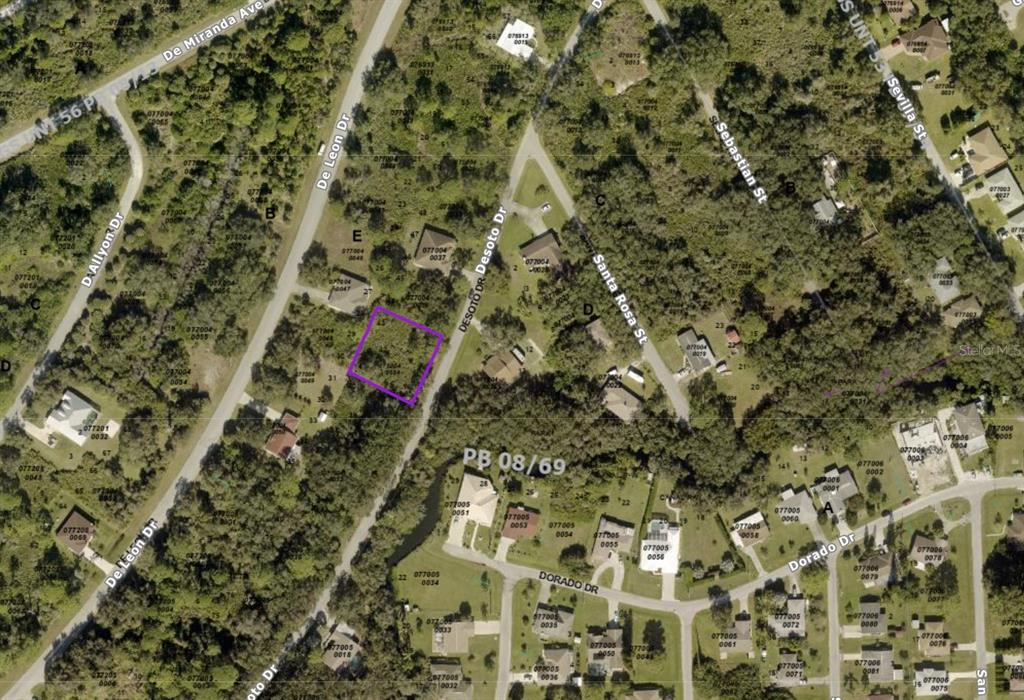 This is an aerial map showing a highlighted vacant lot surrounded by wooded residential streets — 0770040034 DESOTO DRIVE, NORTH PORT, FL