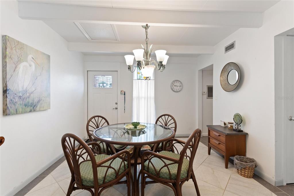 A dining room features a glass-topped table, four rattan chairs, and a chandelier — 1823 CLUB CIRCLE, LAKE WALES, FL