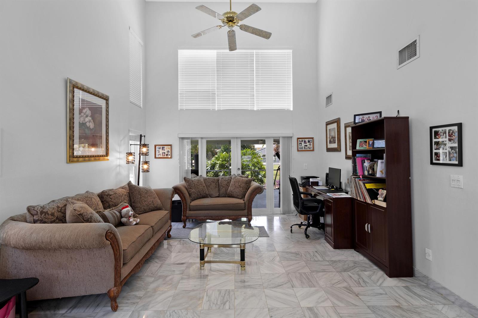 A living room with high ceilings, marble floors, a sofa, a loveseat, and a desk — 5525 NW 54th Circle, Coconut Creek FL 33073, COCONUT CREEK, FL
