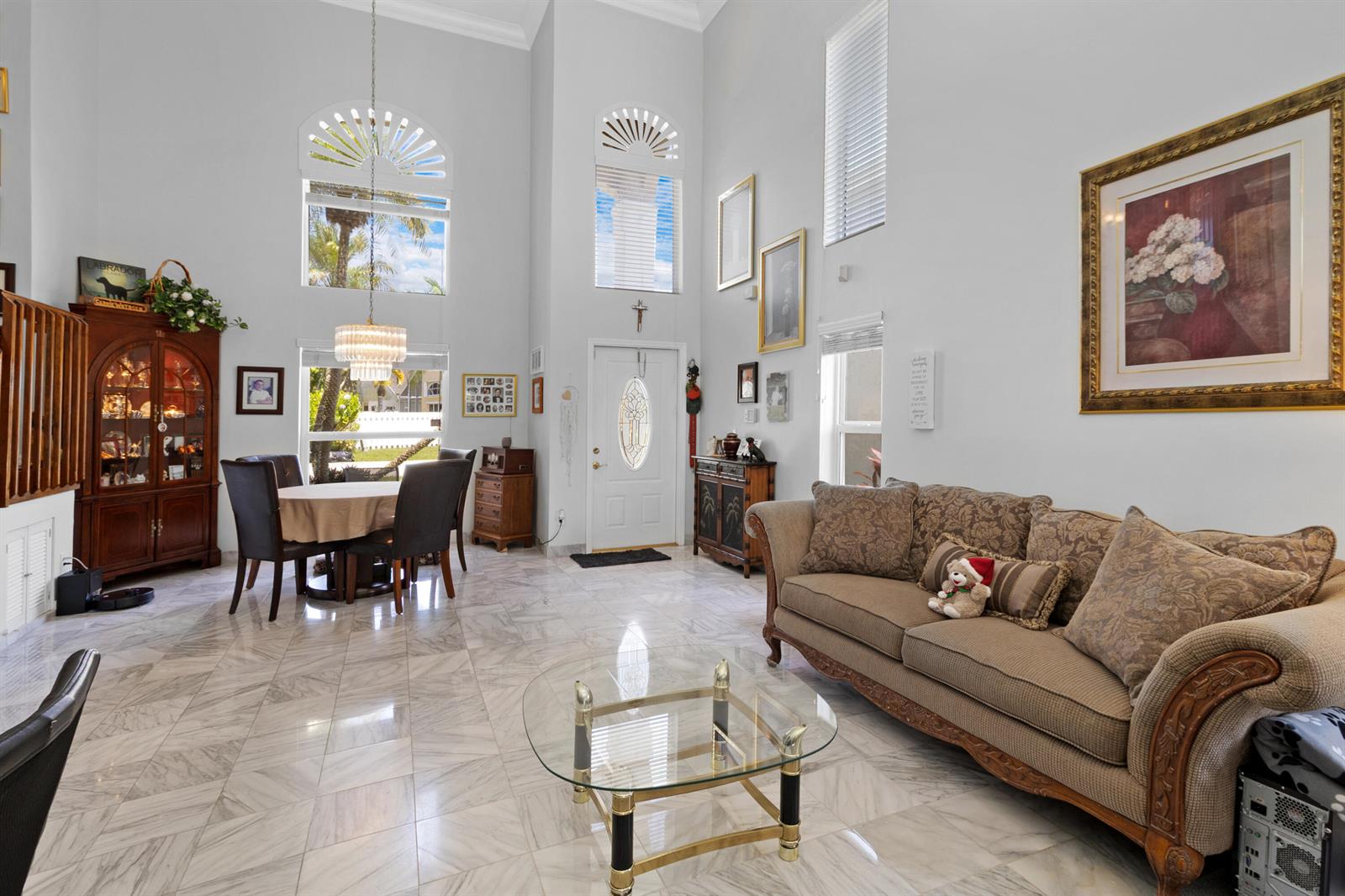 A high-ceilinged living and dining room features marble flooring, a glass coffee table, and furniture — 5525 NW 54th Circle, Coconut Creek FL 33073, COCONUT CREEK, FL