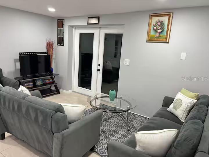 A living room features two gray sofas, a glass coffee table, and double glass doors — 735 BERTREND STREET, ENGLEWOOD, FL
