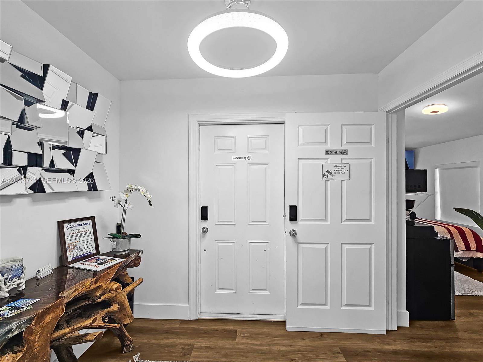 A white door with a digital lock stands in a room with wood flooring — 621 NW 59th Ave, Miami FL 33126, MIAMI, FL