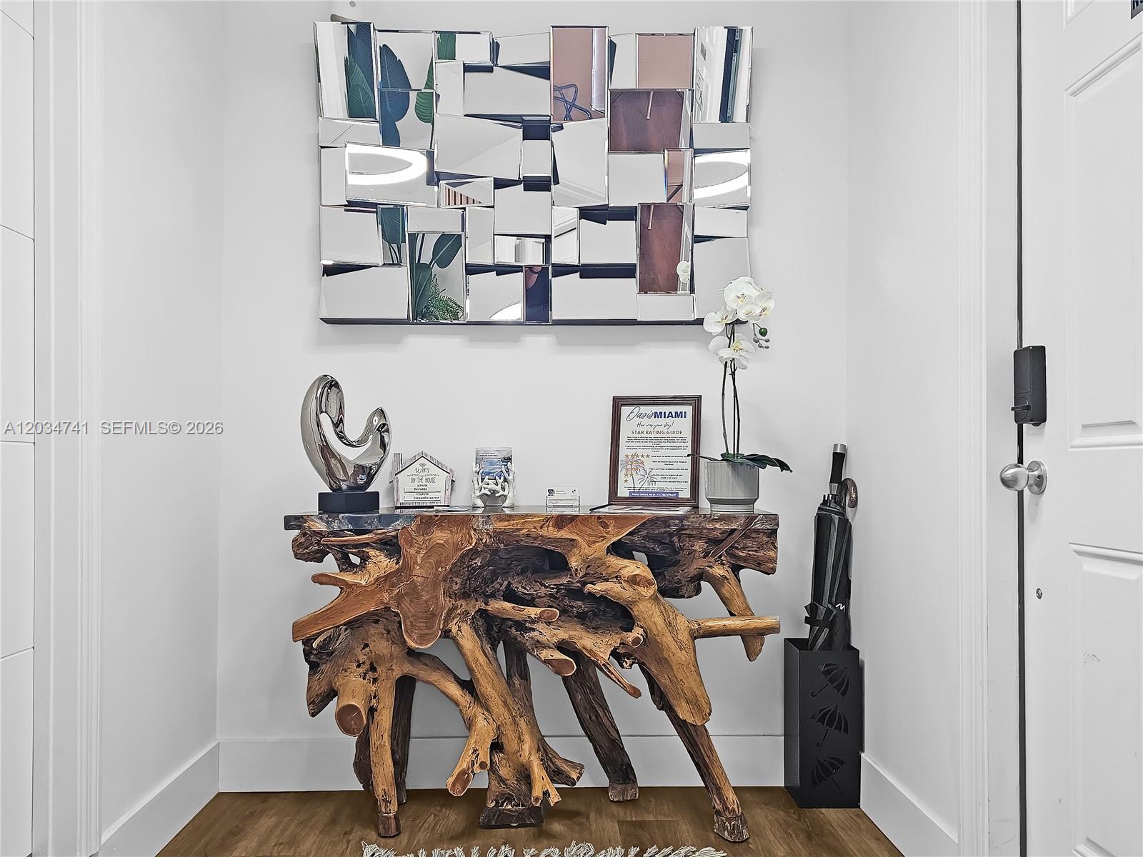 An entryway features a rustic wood root console table, a geometric mirror, and an umbrella stand — 621 NW 59th Ave, Miami FL 33126, MIAMI, FL