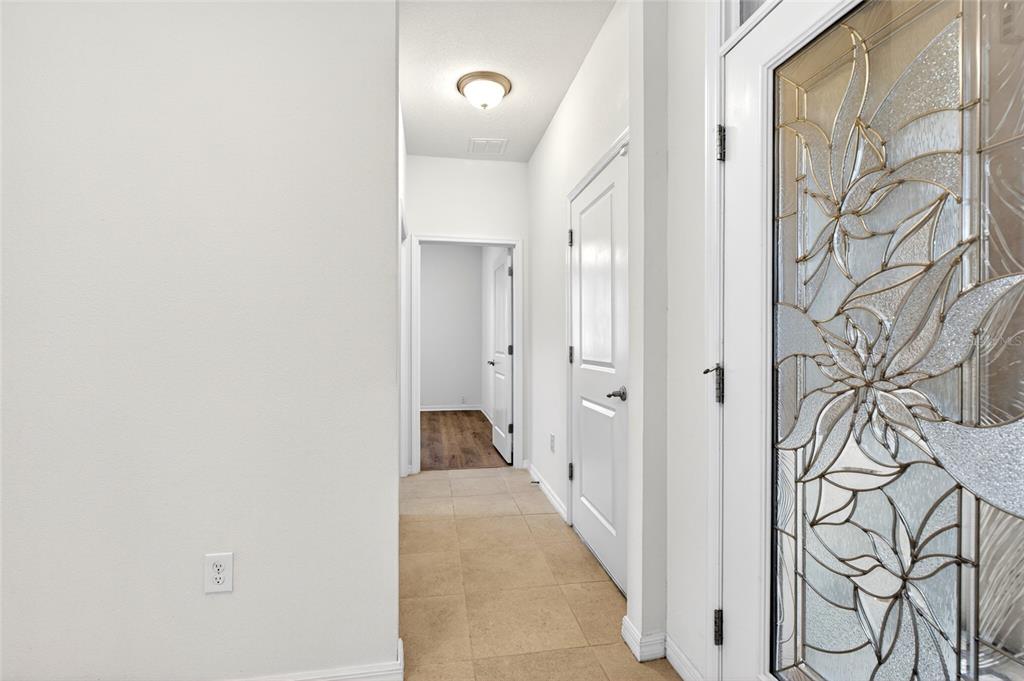 A tiled entryway features a white front door with decorative glass and a hallway beyond — 9149 SW 62ND TERRACE ROAD, OCALA, FL