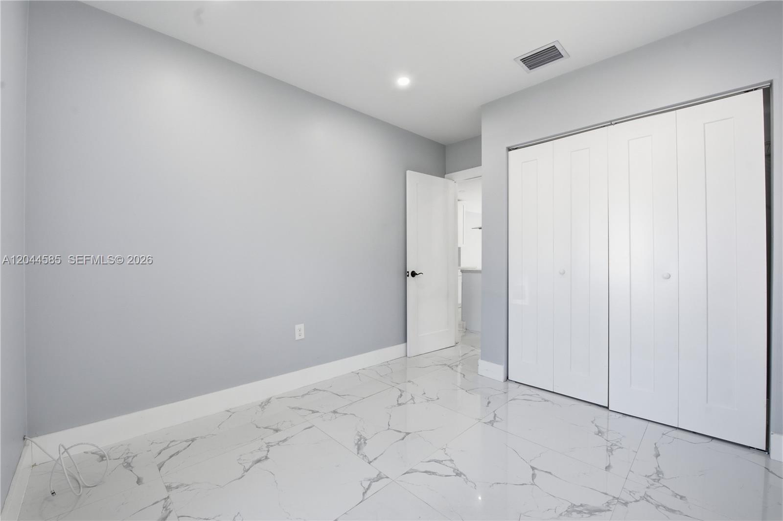 This room features light gray walls, white trim, and white marble-patterned tile flooring — 12475 NW 10th Ave, North Miami FL 33168, NORTH MIAMI, FL