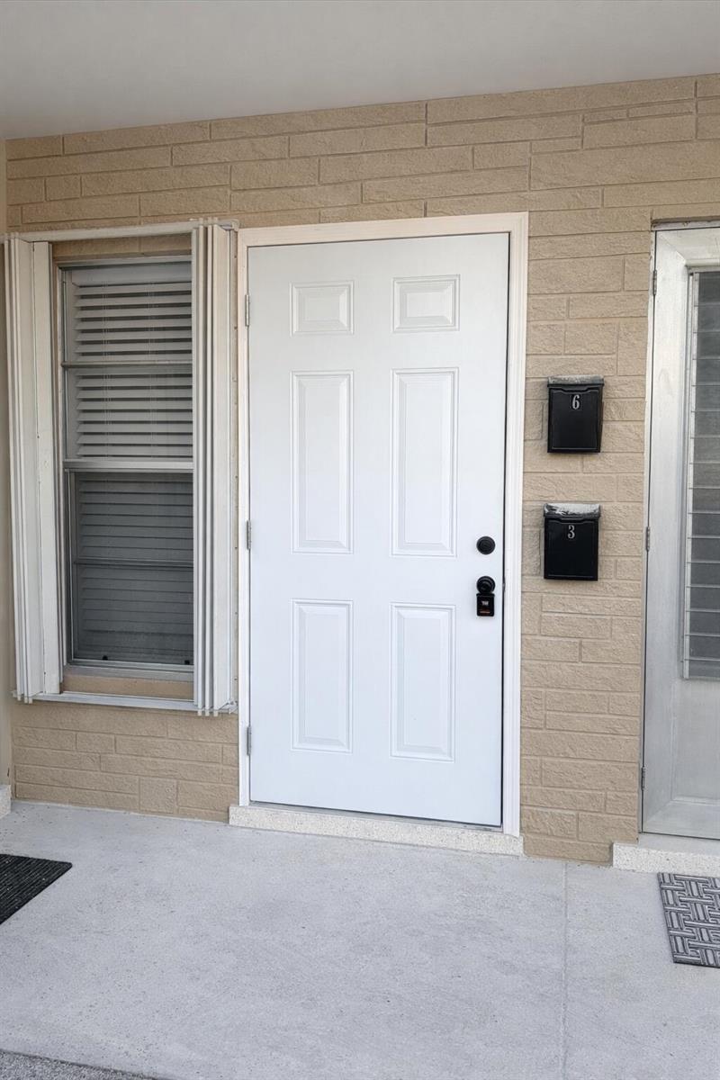 A white six-panel front door sits beside a window and two black mailboxes on brick — 1017 SE 3rd Street # 3, Deerfield Beach FL 33441, DEERFIELD BEACH, FL
