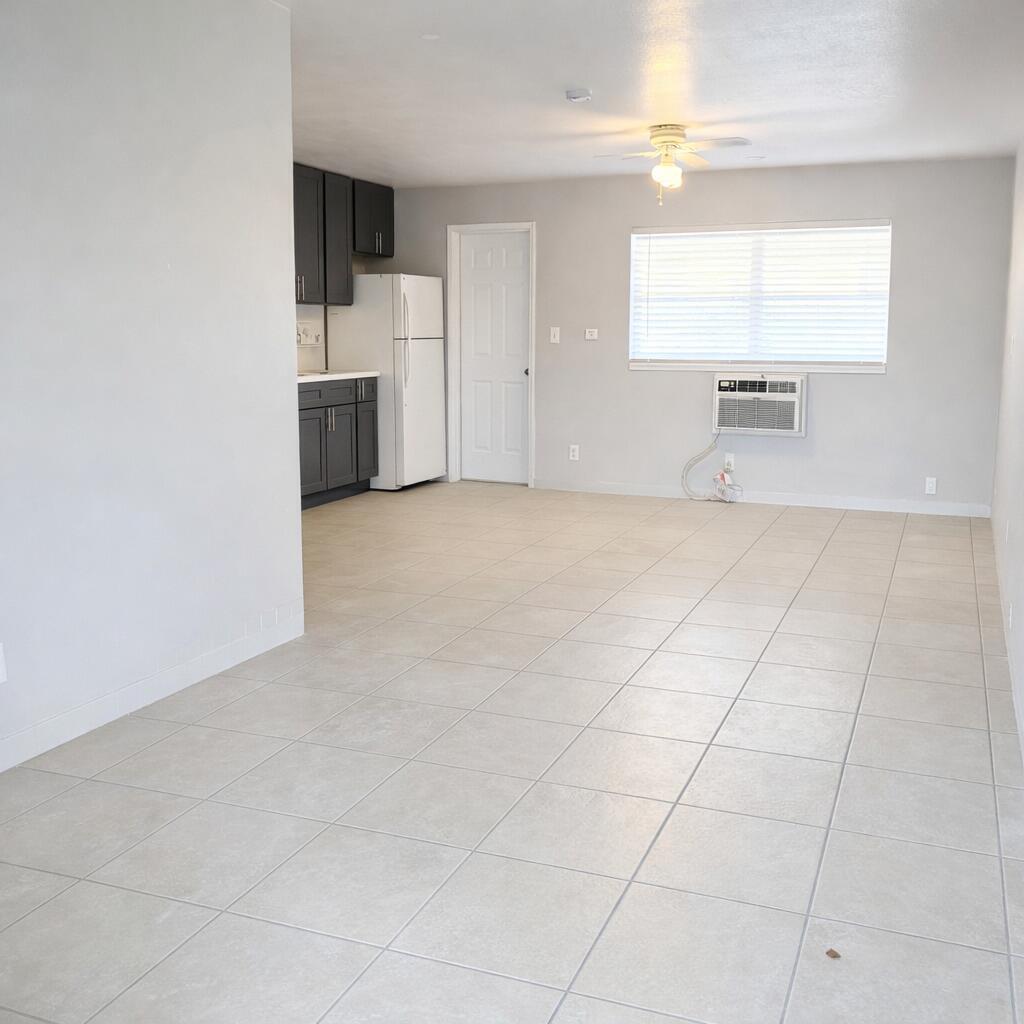 An open-concept living area features light tile flooring, a ceiling fan, and a small kitchen — 1017 SE 3rd Street # 3, Deerfield Beach FL 33441, DEERFIELD BEACH, FL