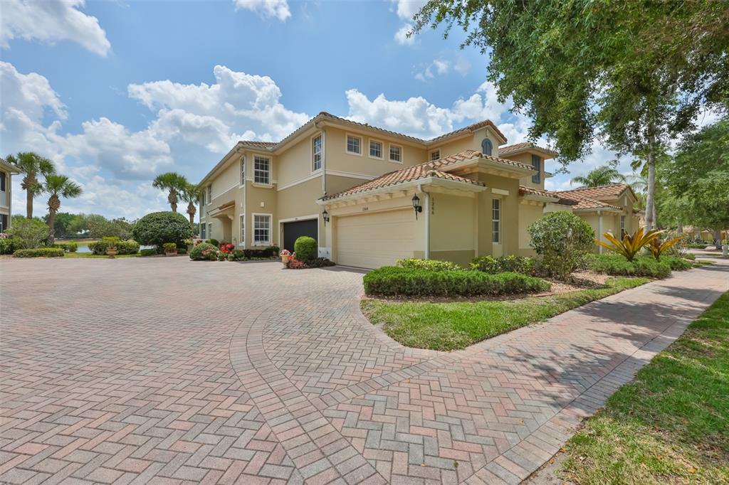 A two-story stucco house with a tile roof and a brick paver driveway — 1368 EMERALD DUNES DRIVE, SUN CITY CENTER, FL