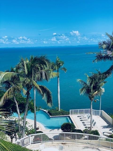 An elevated view of a swimming pool overlooking the ocean with palm trees and railings — LAS CASITAS VILLAGE 1 AVE CONQUISTADOR UNIT 5391, FAJARDO, PR