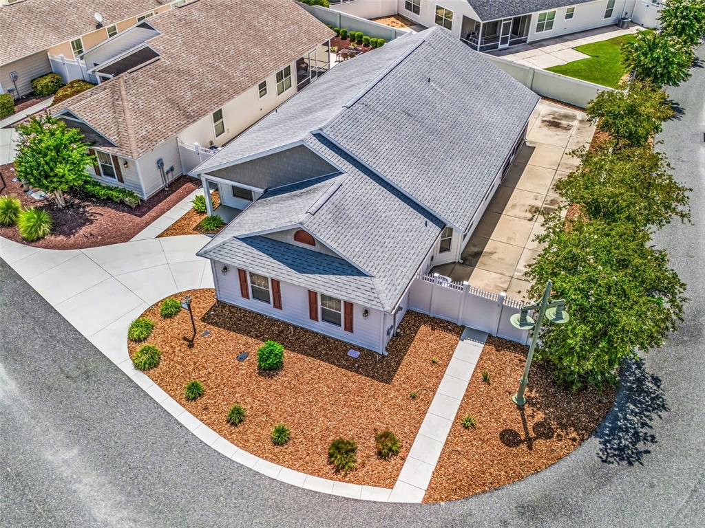 An aerial view shows a single-story house with a gray roof and landscaped front yard — 1134 SOUTHERN SUN DRIVE, THE VILLAGES, FL