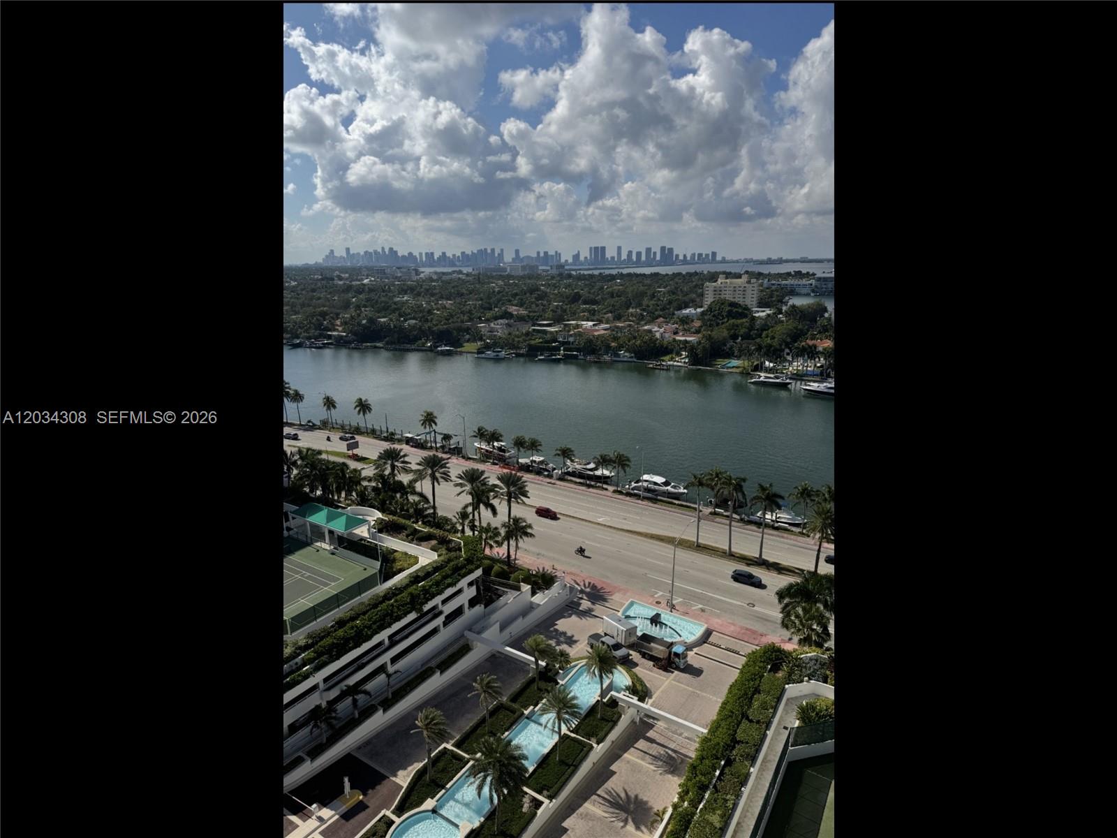 An elevated view shows a coastal road, a waterway, and a distant city skyline — 4779 Collins Ave # 1804, Miami Beach FL 33140, MIAMI BEACH, FL