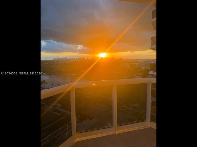 A balcony view overlooking a city skyline and a body of water at sunset — 4779 Collins Ave # 1804, Miami Beach FL 33140, MIAMI BEACH, FL