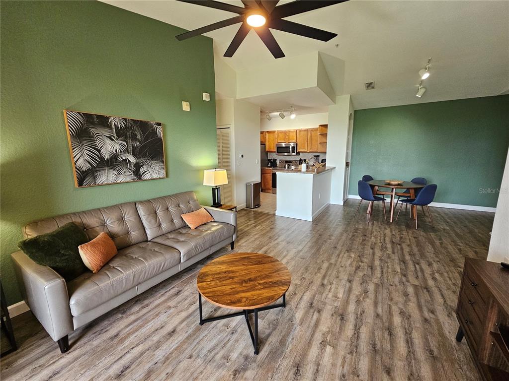 A living room and dining area with green accent walls and wood-look flooring — 8335 38TH STREET CIRCLE E UNIT 305, SARASOTA, FL