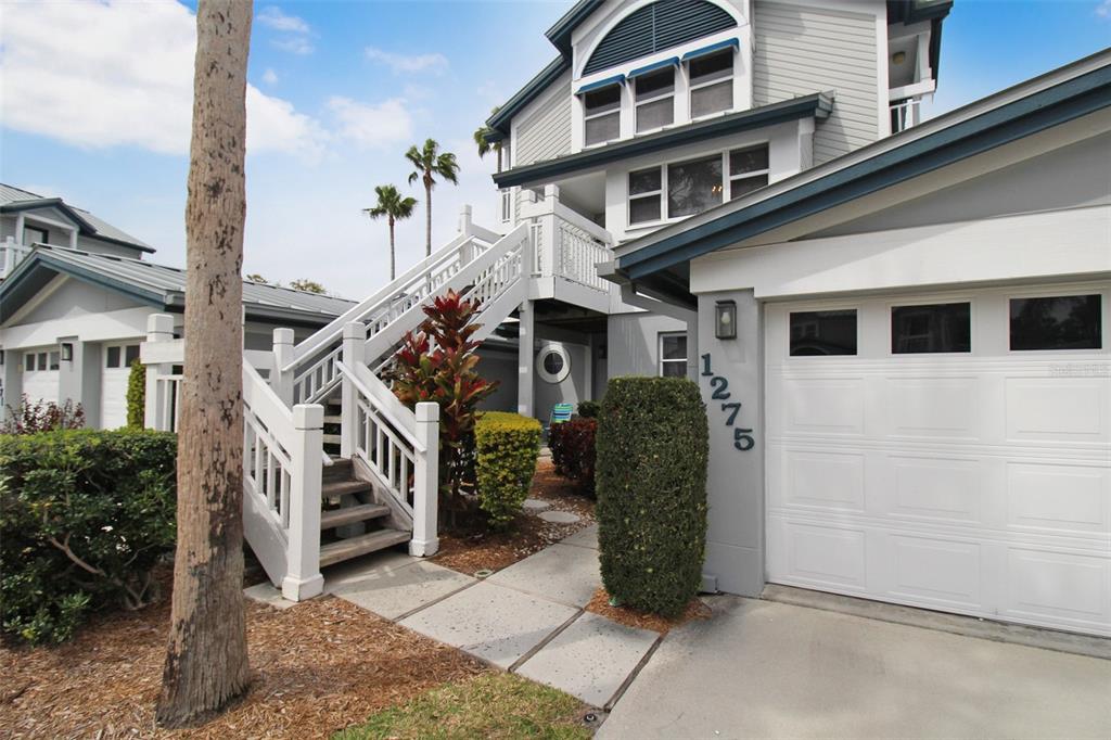 A multi-story house exterior features a white staircase, a garage, and a landscaped front yard — 1275 SIESTA BAYSIDE DRIVE UNIT 1275-B, SARASOTA, FL