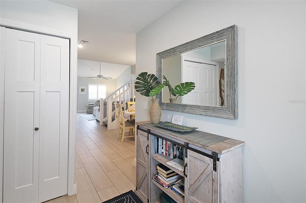 A hallway features a rustic console table with a mirror and a view into the living area — 1275 SIESTA BAYSIDE DRIVE UNIT 1275-B, SARASOTA, FL