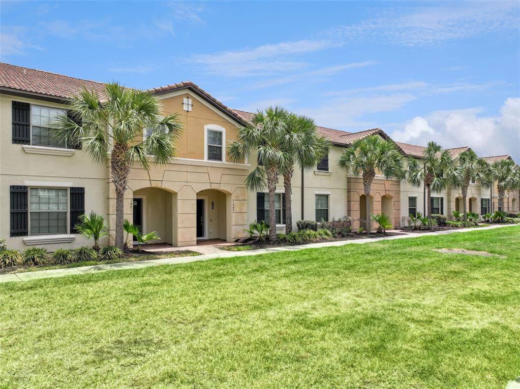 A two-story apartment building with stucco walls, tile roofs, and palm trees on a lawn — 1909 MAJORCA DRIVE, KISSIMMEE, FL