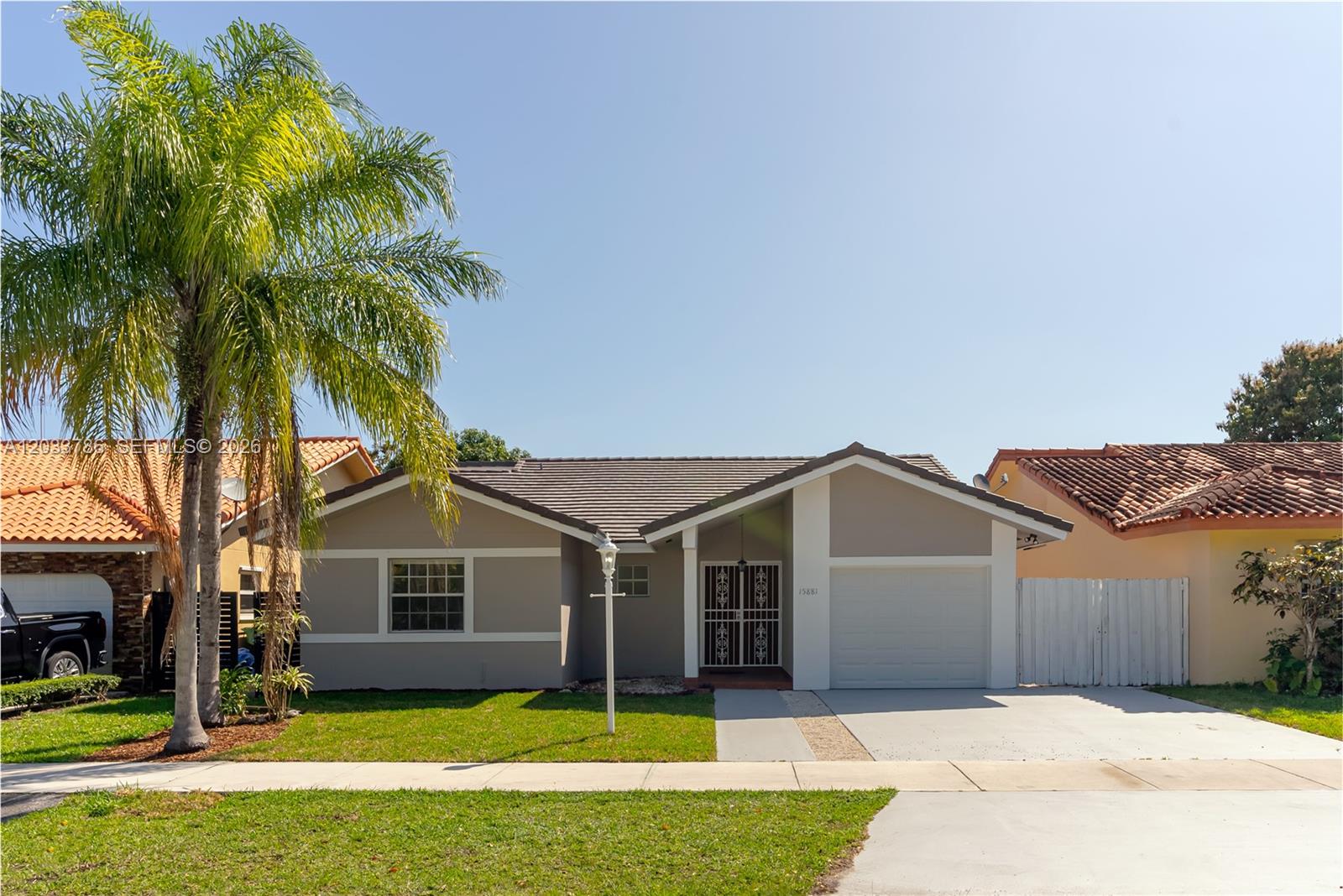 A single-story house with a gray exterior, a palm tree, and a concrete driveway — 15881 SW 139th Ave, Miami FL 33177, MIAMI, FL