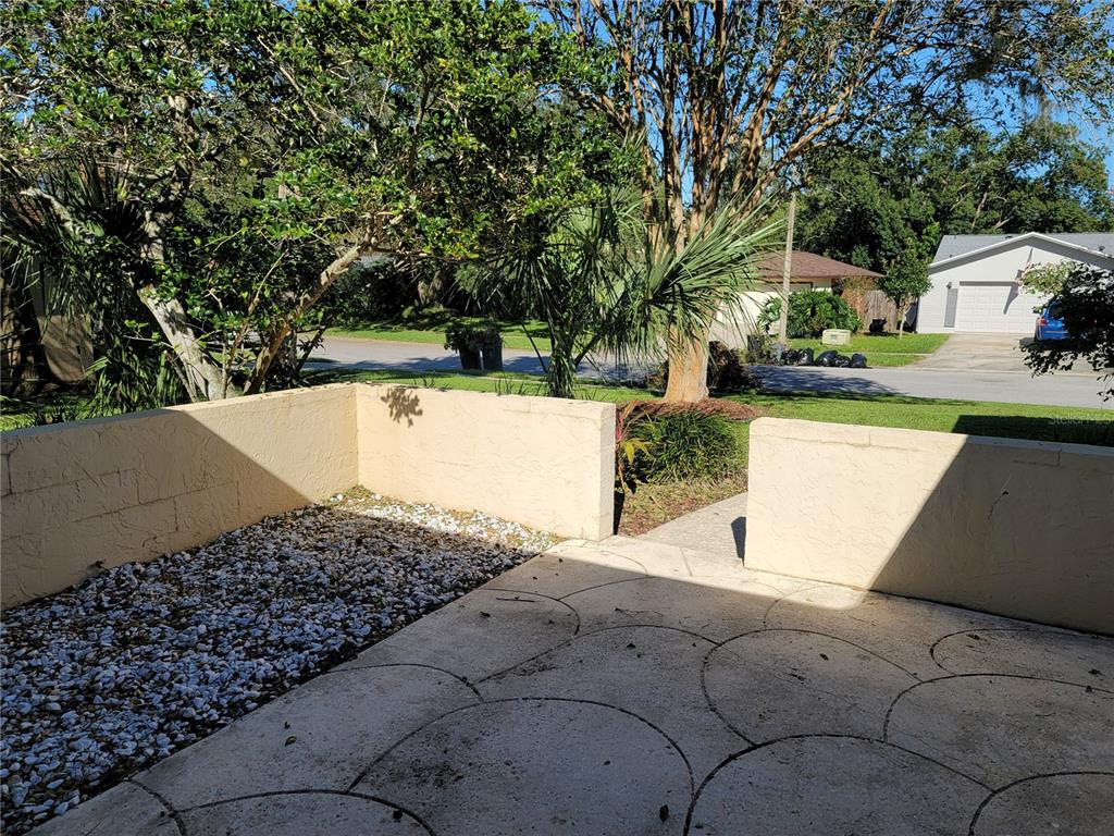 A concrete patio with a gravel section is enclosed by a low stucco wall — 622 GREEN MEADOW AVENUE, MAITLAND, FL