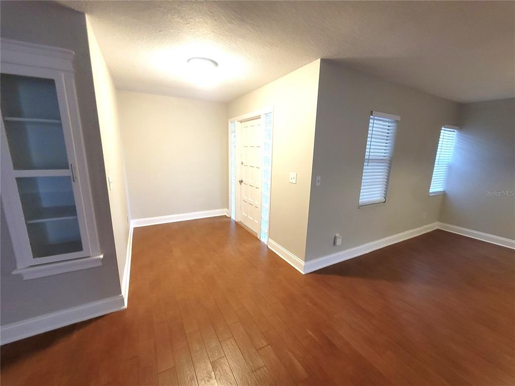 An interior room features light gray walls, hardwood flooring, a glass-paneled door, and white trim — 622 GREEN MEADOW AVENUE, MAITLAND, FL