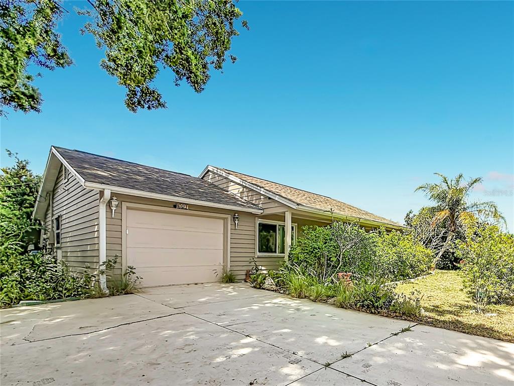 A single-story house with tan siding, a one-car garage, and a concrete driveway — 601 E SEMINOLE DRIVE, VENICE, FL