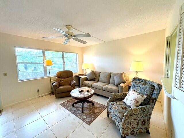A living room features a beige sofa, two armchairs, a round coffee table, and tile flooring — 116 Windsor F, West Palm Beach FL 33417, WEST PALM BEACH, FL