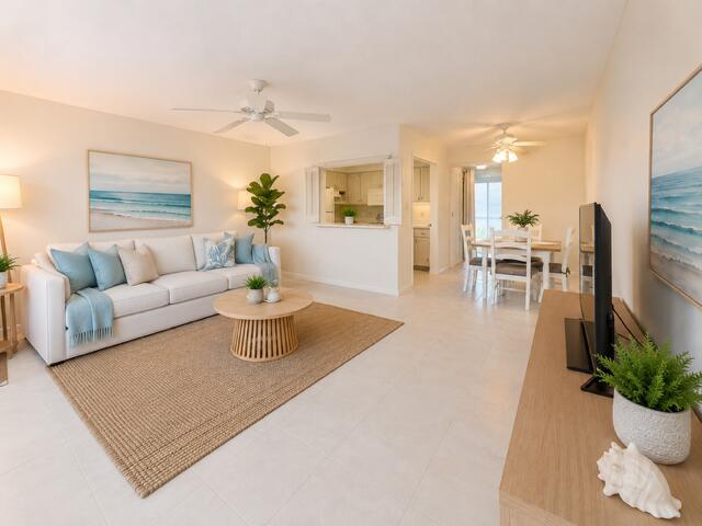 A bright living room features a white sofa, a round coffee table, and tile flooring — 116 Windsor F, West Palm Beach FL 33417, WEST PALM BEACH, FL