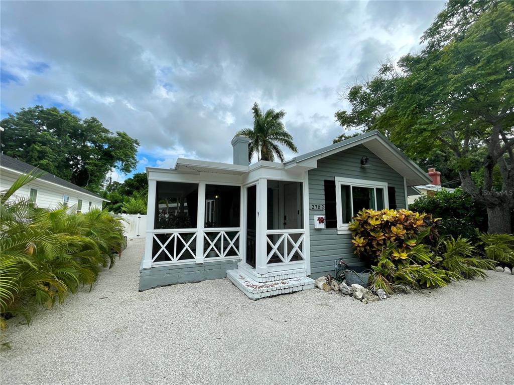 A gray house with a white screened-in porch and a gravel driveway — 2703 10TH AVENUE W, BRADENTON, FL