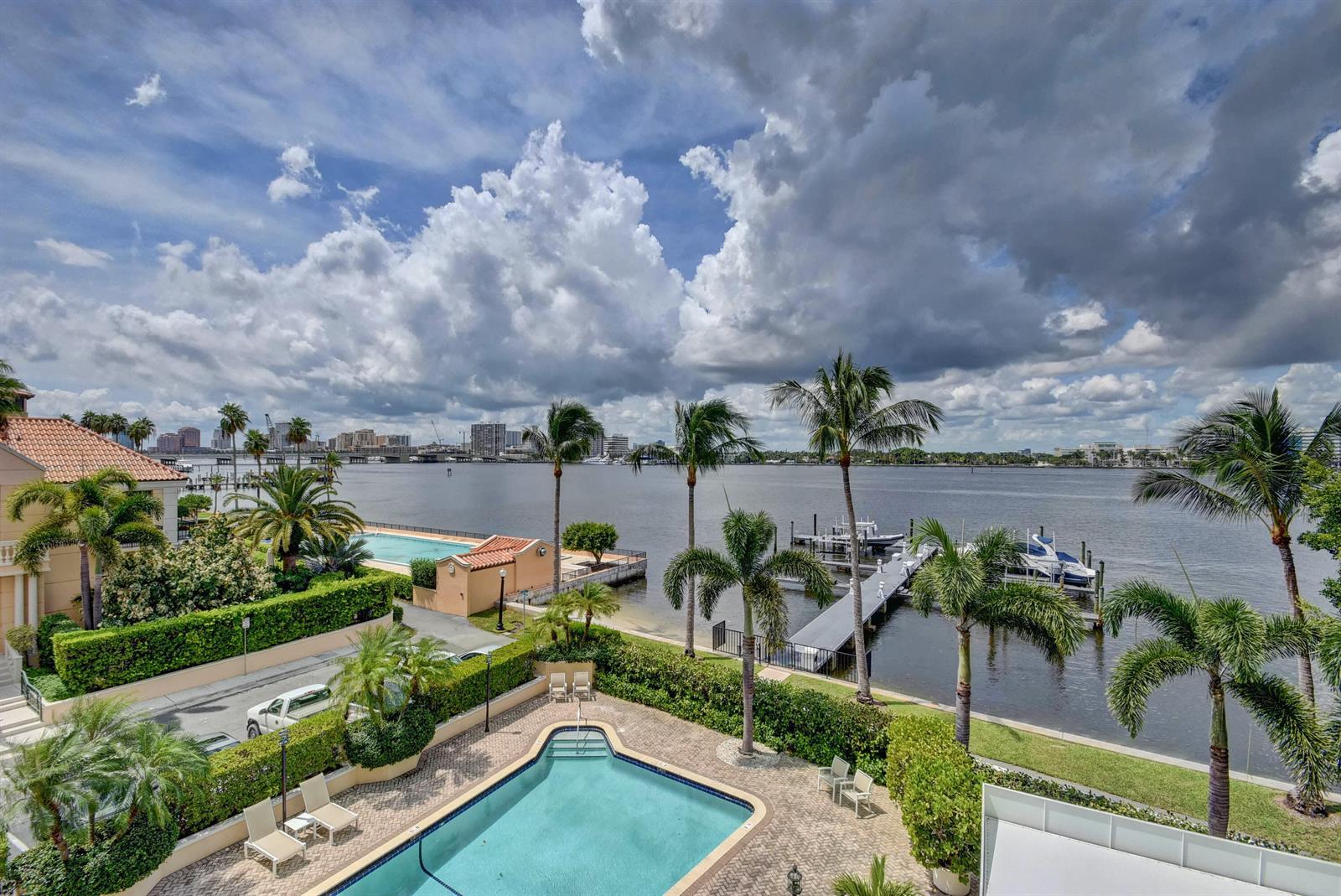 An elevated view of a swimming pool, palm trees, a boat dock, and a river — 250 Bradley Place # 408, Palm Beach FL 33480, PALM BEACH, FL