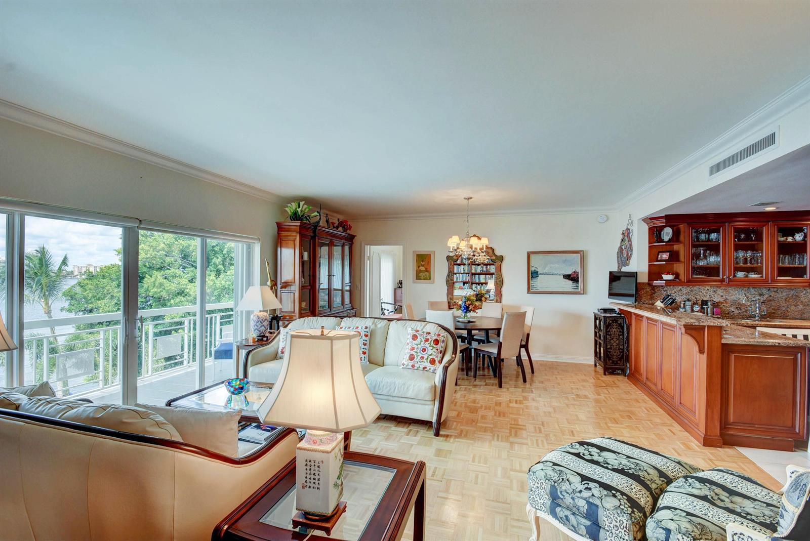 A living and dining area with hardwood floors, a wet bar, and a balcony view — 250 Bradley Place # 408, Palm Beach FL 33480, PALM BEACH, FL