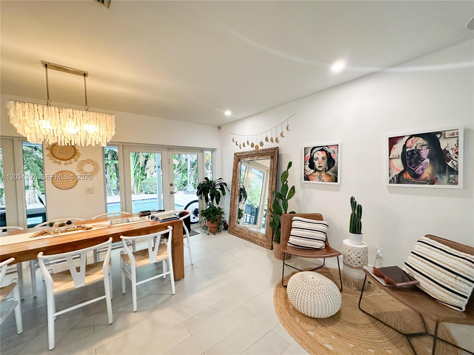 A dining area features a wooden table, white chairs, a large mirror, and wall art — 20931 NE 24th Ave, Miami FL 33180, MIAMI, FL